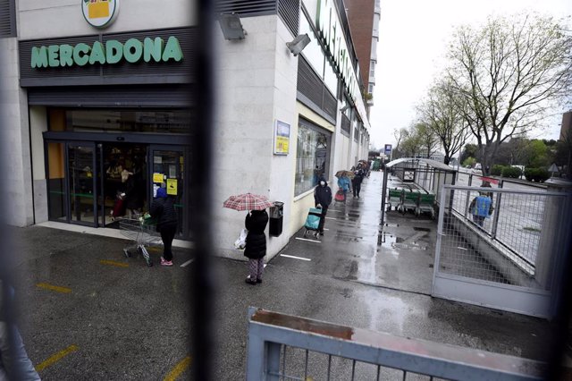 Varias personas esperan para poder entrar a comprar en un supermercado Mercadona de Madrid en plena crisis sanitaria por coronavirus donde los españoles llevan confinados en sus hogares más de una semana, en Madrid (España), a 23 de marzo de 2020.