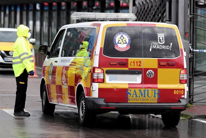 Una trabajadora de seguridad habla con el conductor de una ambulancia del SAMUR que llega a Ifema