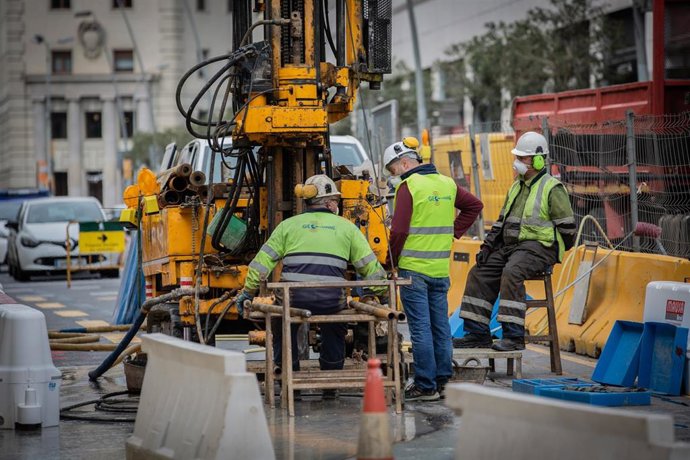 Diversos obrers treballen remodelant un carrer durant l'estat d'alarma per coronavirus, a Barcelona