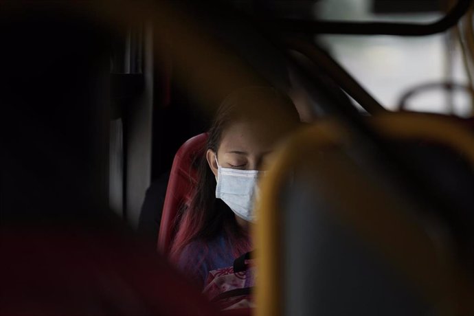 Una mujer porta una mascarilla mientras viaja en un autobús en Bogotá, Colombia.