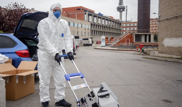 Un técnico protegido con un traje, guantes y mascarilla en el Hospital Gregorio Marañón antes de montar un respirador