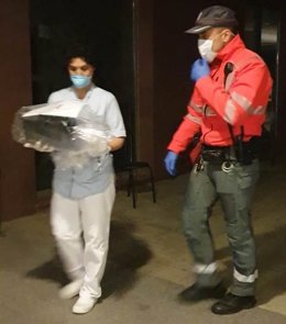 Un agente de Policía Foral entrega material donado por ciudadanos a personal sanitario para luchar contra el coronavirus.