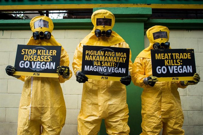 13 February 2020, Philippines, Manila: Supporters of the People for the Ethical Treatment of Animals (PETA) wear biohazard suits as they protest to demand everyone to go vegan and blame the consumption of meat for the spread of coronavirus, outside the 