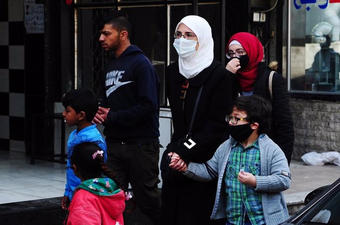 Una familia siria con mascarillas en Damasco