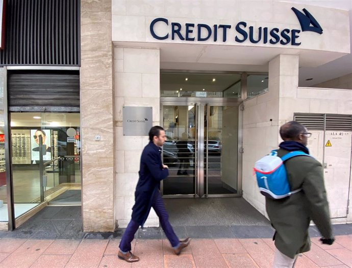 Dos hombres pasan junto a la entrada de la sede de Credit Suisse en Madrid (España), a 29 de enero de 2020.
