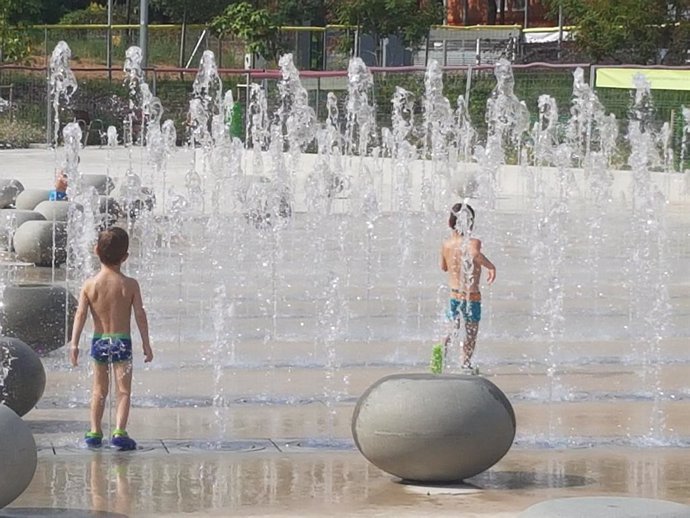 Nens refrescant-se en les fonts del parc Santiburcio de Barcelona
