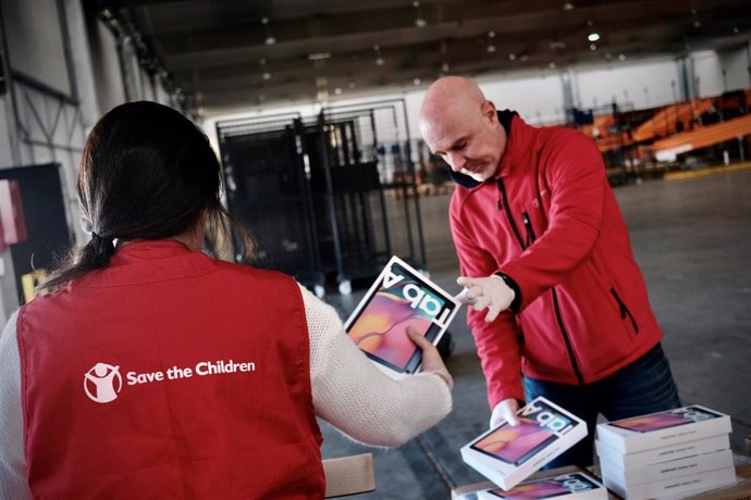Trabajadores de la organización Save The Children ordenan las cajas de las tabletas donadas por Samsung para familias en riesgo de exclusión.