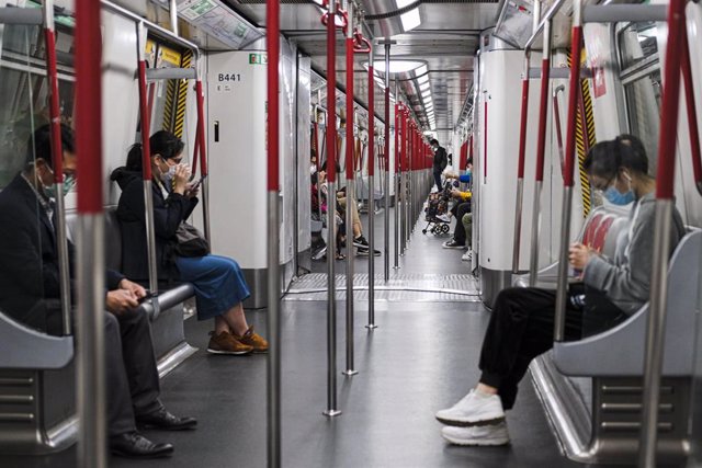 Pasajeros del metro de Hong Kong ataviados con mascarillas para evitar contraer el coronavirus.