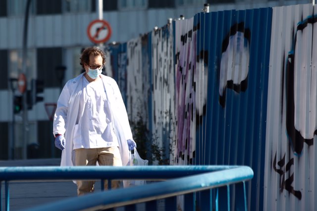 Un sanitario protegido con una mascarilla y guantes sale del Hospital La Paz, centro en cuyas dependencias se ha instalado una carpa que sirve como ampliación de las Urgencias del centro.