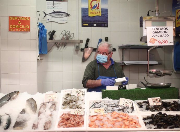 Un trabajador del Mercado municipal Barceló ordena los productos alimenticios en su puesto de trabajo en plena crisis del coronavirus.
