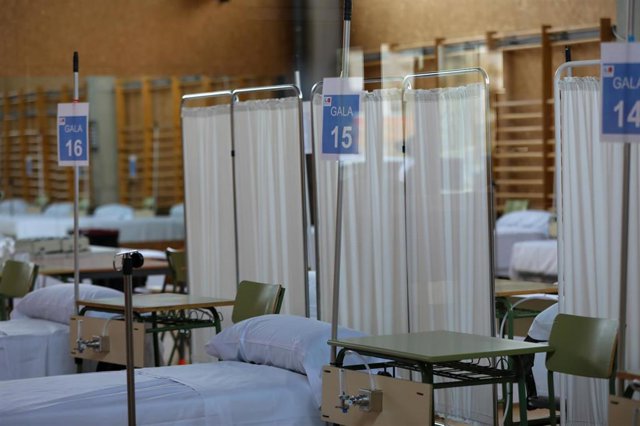 Camas numeradas y separadas con biombos