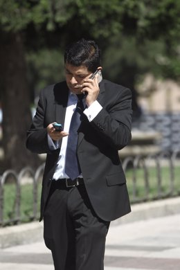 Un hombre camina mientras habla por su teléfono móvil.