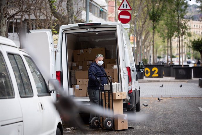 Un home protegit amb mascarilla treballa de repartidor durant el nov dia laborable des que es va decretar l'estat d'alarma al país a conseqüncia del coronavirus, a Barcelona/Catalunya (Espanya) a 26 de mar de 2020.
