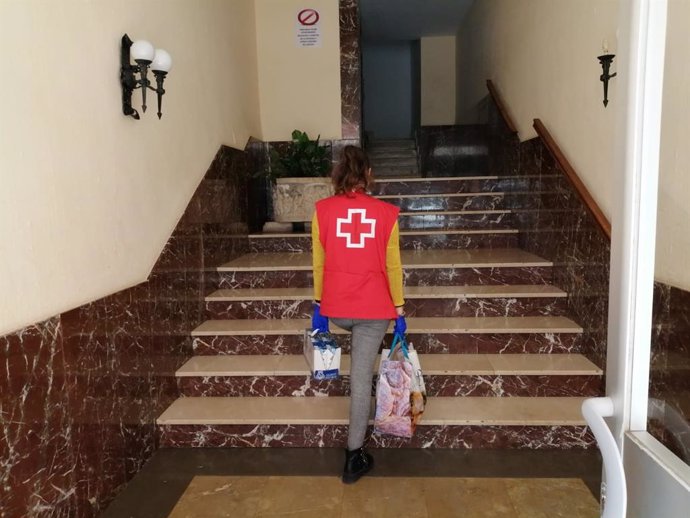 Entrega de alimentos a domicilio por voluntarios de Cruz Roja.