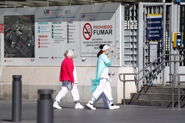 Dos sanitarias protegidas con mascarillas se dirigen a la entrada del Hospital La Paz.