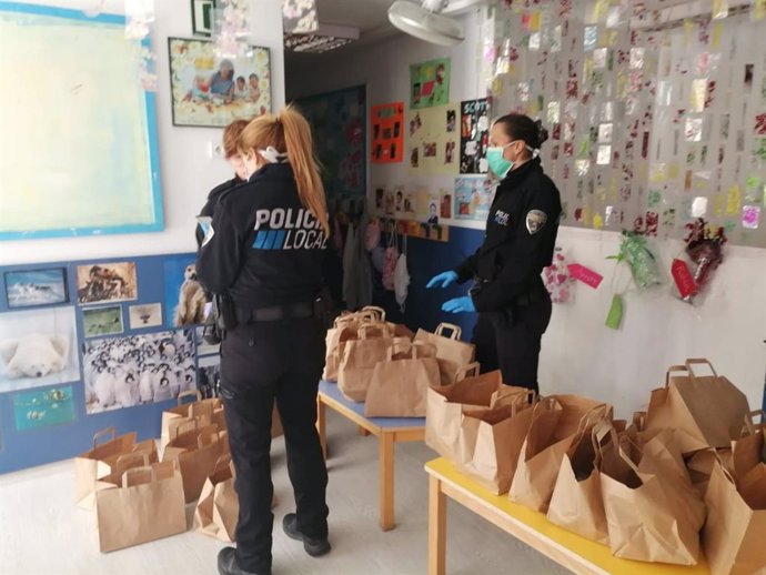 Agentes de la Policía Local preparan el reparto de comida.