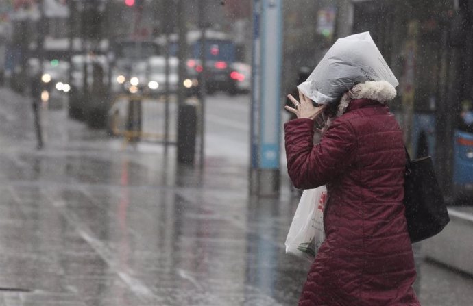 Una mujer se refugia de la lluvia con una bolsa de plástico, en Madrid (España), a 5 de marzo de 2020.