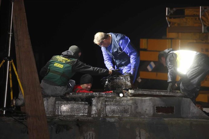Agentes de la Policía y de la Guardia Civil descargan cocaína del narcosubmarino hundido  a la entrada de la ría de Aldán, en Cangas (Pontevedra) , en noviembre de 2019.