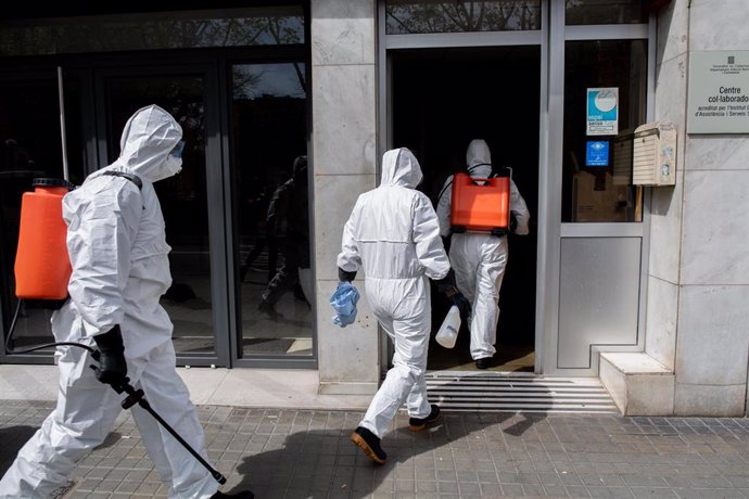 Efectivos de la Unidad Militar de Emergencias entran en una residencia de ancianos con afectados por el Coronavirus en el barrio de El Clot de Barcelona para realizar tareas de desinfección