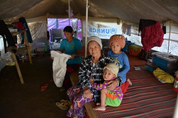 Imagen de una aldeana con sus nietos en Kachín.