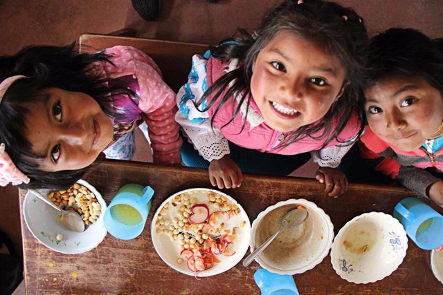 Unas niñas comiendo en una escuela en Ecuador