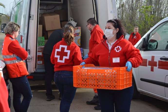 Voluntarios de Cruz Roja reparten material.