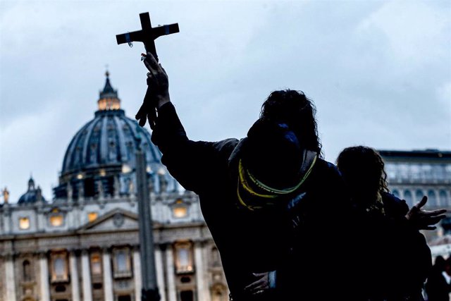 Creyente levanta una cruz frente al Vaticano