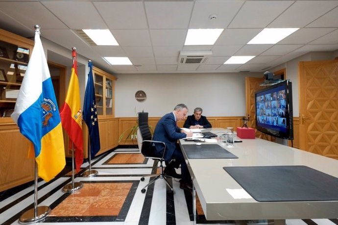 El presidente de Canarias, Ángel Víctor Torres, y al fondo el vicepresidente, Román Rodríguez, este domingo durante la videoconferencia con Sánchez y los presidentes autonómicos