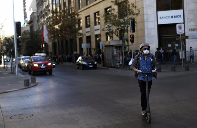 Una persona transita por Santiago de Chile con una  mascarilla para evitar la propagacion del coronavirus