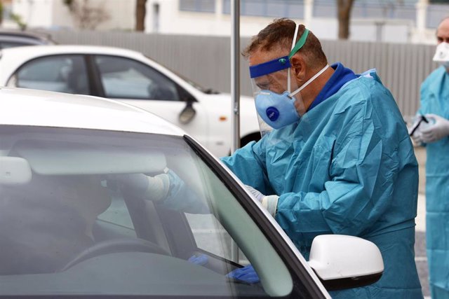 Dispositivo sanitario de la prueba test del PCR para detectar la infección por coronavirus a las personas desde su coche, instalado en el recinto de aparcamiento del centro de salud de la barriada La Roca, en Málaga, (Andalucía, España)