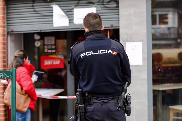 Un agente de la Policía Nacional supervisa la recogida de menús infantiles en Madrid