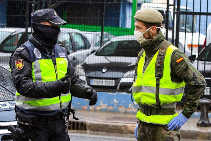 Un militar del Ejército y un agente de la Policía Nacional realizan controles de tráfico a la salida de la ciudad durante un viernes del estado de alarma decretado por coronavirus, en Valencia (Comunidad Valenciana), a 27 de marzo de 2020.