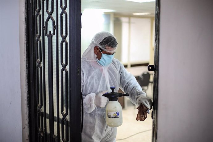 Un trabajador desinfecta un edificio gubernamental en Egipto a causa de la pandemia de coronavirus