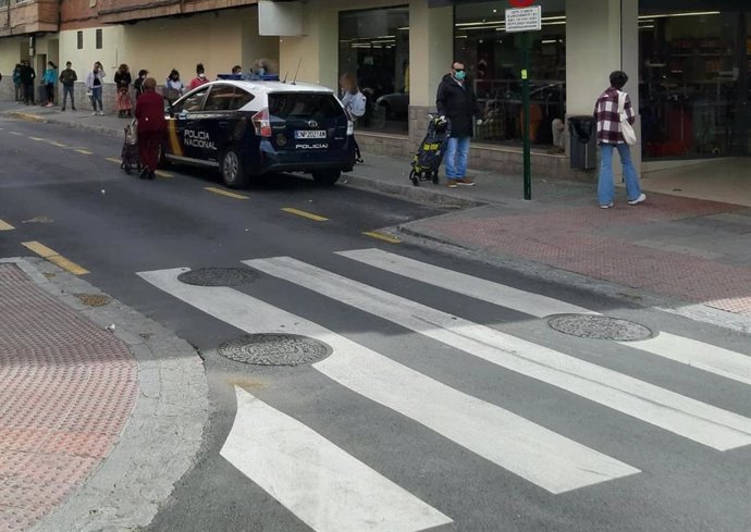 Una patrulla policial ante una cola en un supermercado