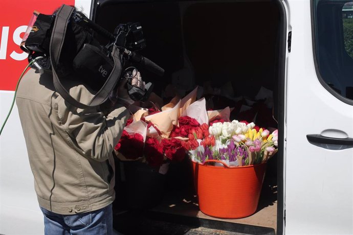 Un periodista graba el interior de una furgoneta repleta de flores que la Fundación Madrina envía para regalar a los sanitarios y para decorar el hospital de campaña en IFEMA, donde se atiende a contagiados por coronavirus derivados de otros centros de 