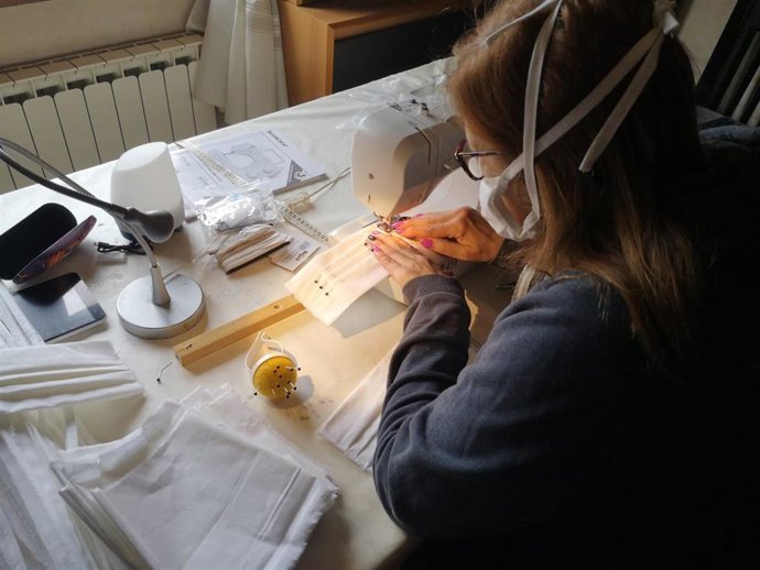Una señora cosiendo mascarillas a máquina