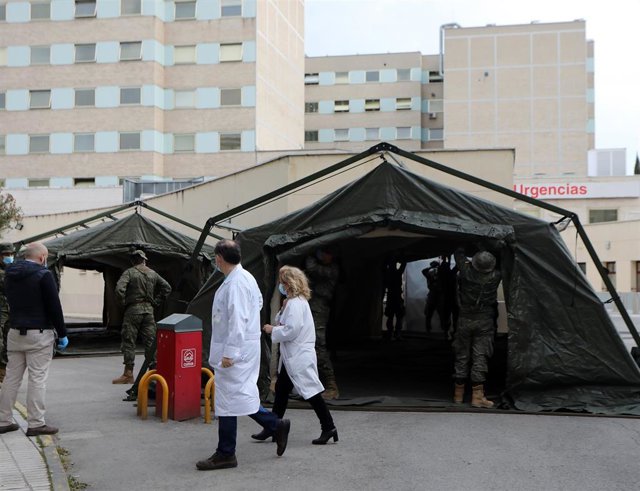 Personal sanitario pasa junto a militares en las inmediaciones del Hospital Gregorio Marañón, en Madrid