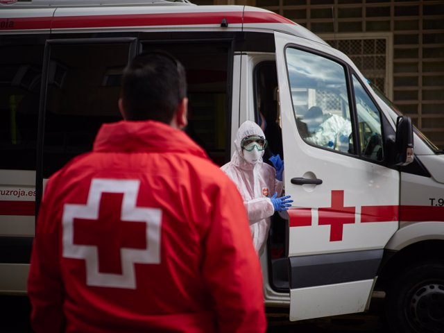 Uno de los trabajadores del Centro de Operaciones de Cruz Roja de Pamplona totalmente protegido sostiene la puerta de la ambulancia minutos antes de dirigirse a la Residencia Hermanitas de los Ancianos de Pamplona.