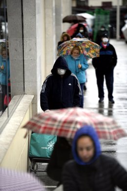 Decenas de personas protegidas hacen cola para poder entrar en un supermercado del barrio madrileño de Usera durante la segunda semana del estado de alarma por coronavirus, en Madrid (España), a 23 de marzo de 2020.