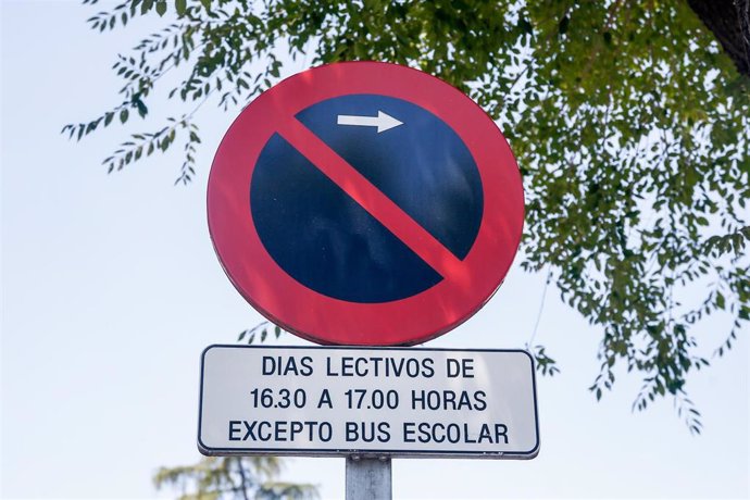 Señal de prohibido aparcar a la derecha (restricción de horas) excepto bus escolar.