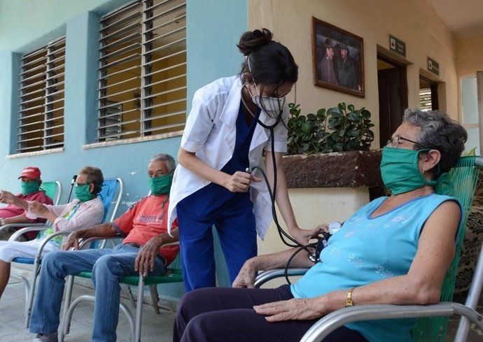 Personal sanitario atendiendo a una persona con mascarilla en Cuba