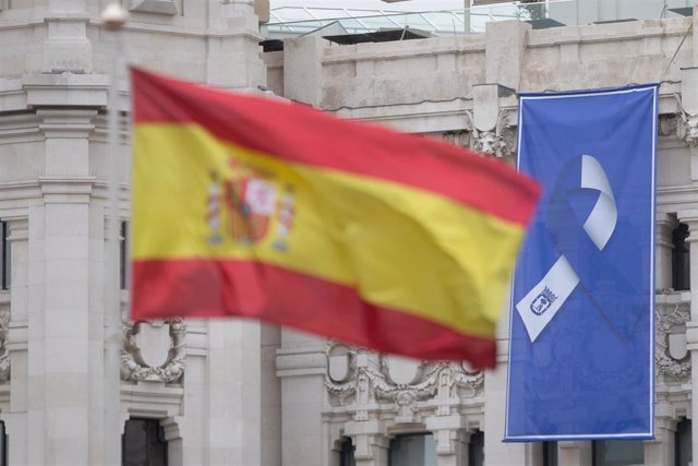 Bandera de España en la Fuente de Cibeles y bandera con el lazo que simboliza la lucha unida del pueblo de Madrid 