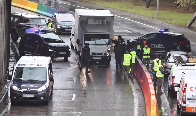 Varios militares del ejército y policías nacionales efectúan un control de tráfico en la carretera de Alcobendas (Madrid) 