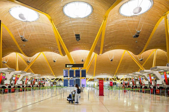 Una turista observa los paneles de la Terminal 4 del Aeropuerto Adolfo Suárez-Madrid Barajas donde el número de vuelos ha bajado notablemente, razón por la que AENA ha decidido agrupar toda la operativa de la T2 y la T3 a la T1, y posteriormente, se pro