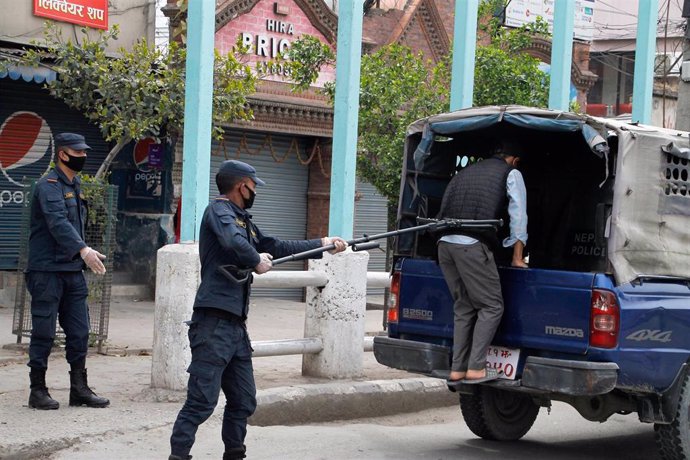 Un policía de Katmandú detiene a un hombre por saltarse la cuarentena. 