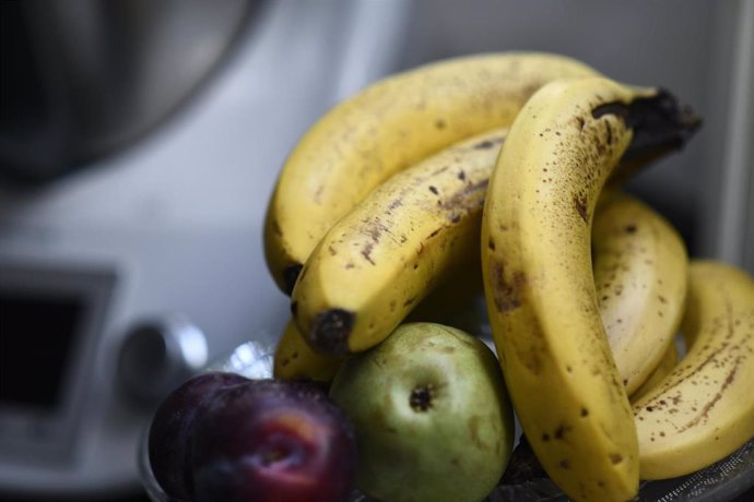 Bodegón de frutas en un plato (plátanos, ciruelas y peras).