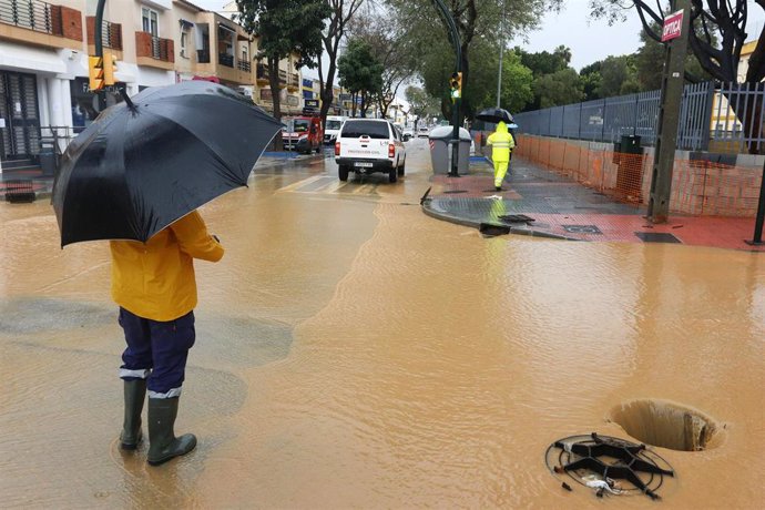 Operarios de los servicios operativos ayudan a retirar el exceso de agua acumulada en la barriada de Campanillas tras el desbordamiento del río  a causa de las fuertes lluvias caída la pasada madrugada. Málaga a 31 de marzo del 2020