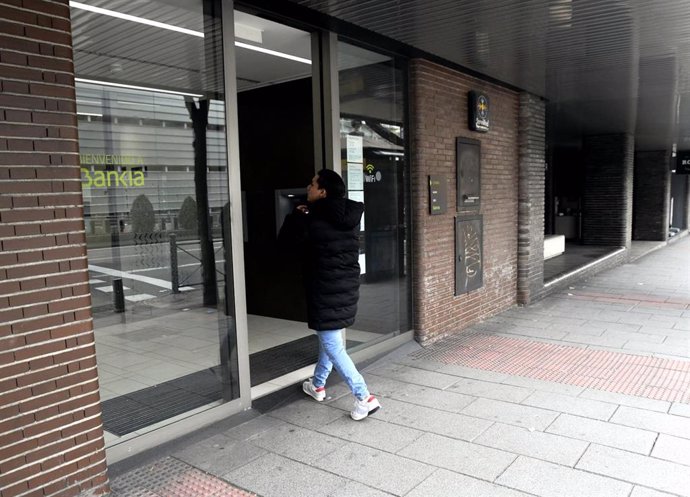 Un hombre entra en una oficina de Bankia, cuyas sucursales permanecen abiertas por ser un servicio imprescindible.