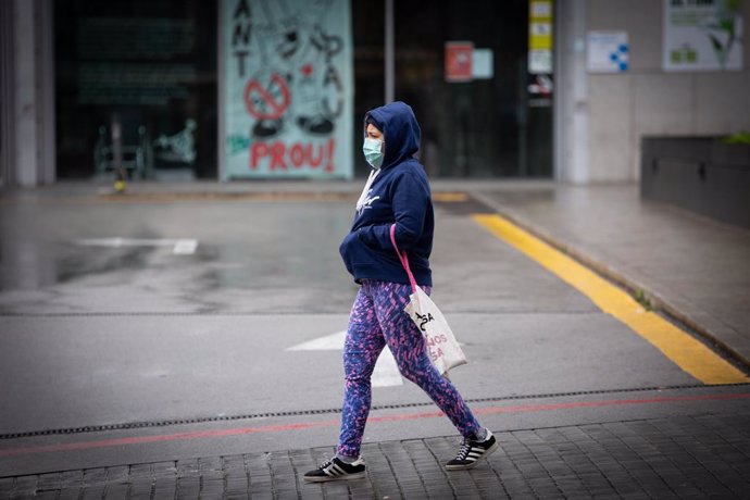 Una dona passa pels voltants de l'Estació de Barcelona Sants durant el dia en el qual entra en vigor la limitació total de moviments com a prevenció del coronavirus. A Barcelona (Catalunya, Espanya) a 30 de mar de 2020.