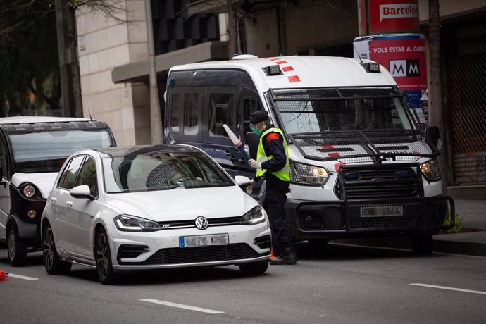 Un Mosso d'Esquadra protegido con una mascarilla en un control de tráfico en la calle Balmes con la Avenida Diagonal de Barcelona, en Barcelona/Catalunya (España) a 31 de marzo de 2020.